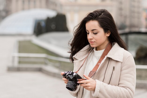 Side view of female photographer outdoors with camera