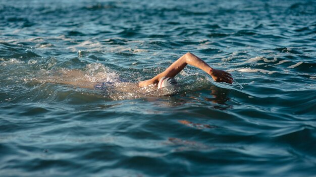 水で泳ぐ女性スイマーの側面図