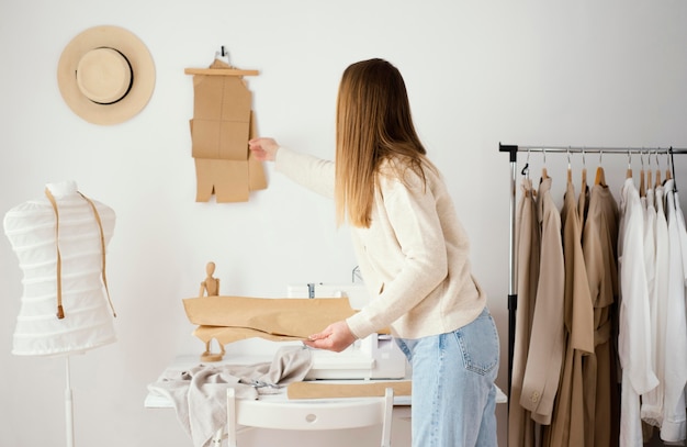 Side view of female tailor working on patterns in the studio