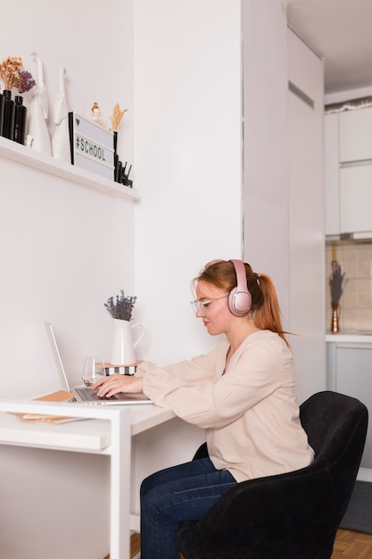 Side view of female teacher at home during online class