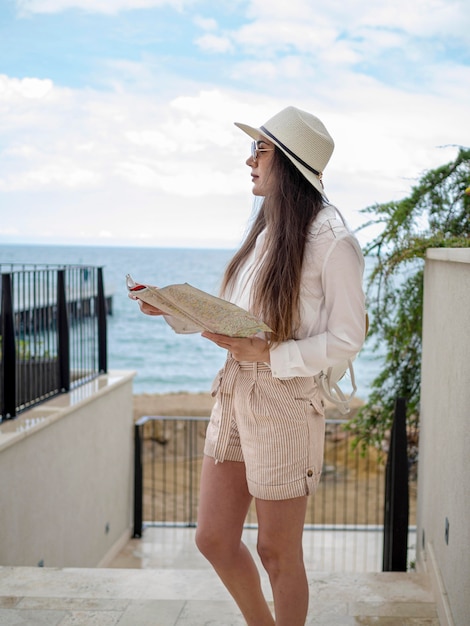 Side view female with map at seaside