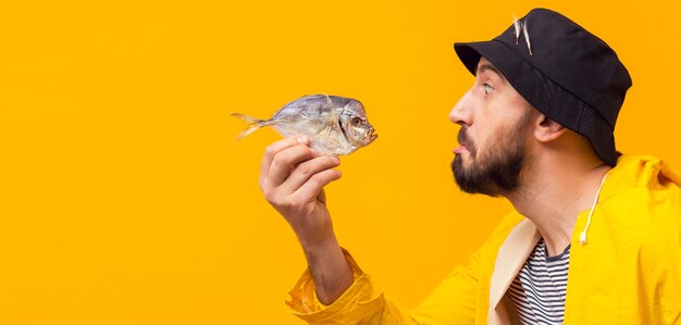 Side view of fisherman holding fish with copy space