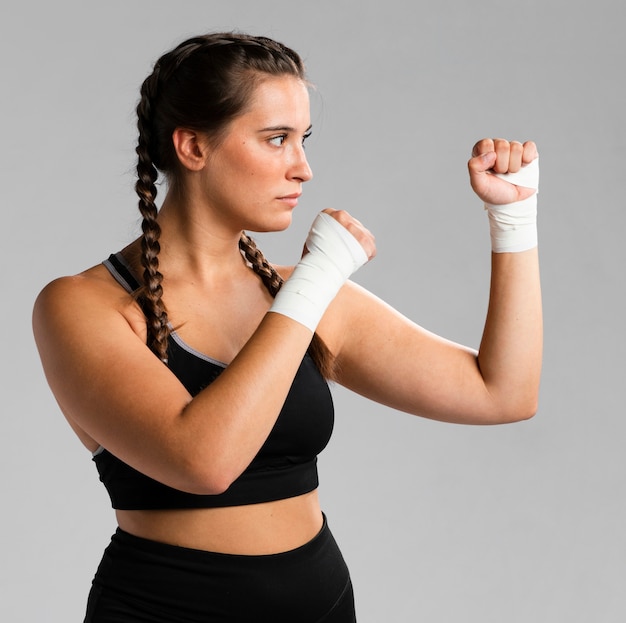 Side view of fit woman in combat position