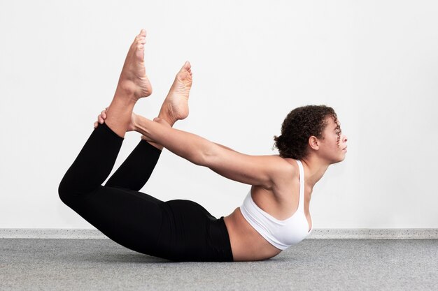 Side view fit woman holding her legs