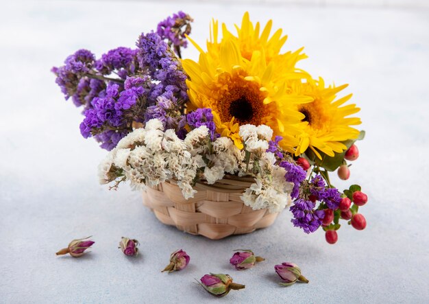 Side view of flowers in basket and on white surface