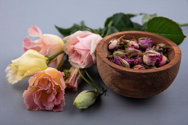 Side view of flowers in bowl and on gray background