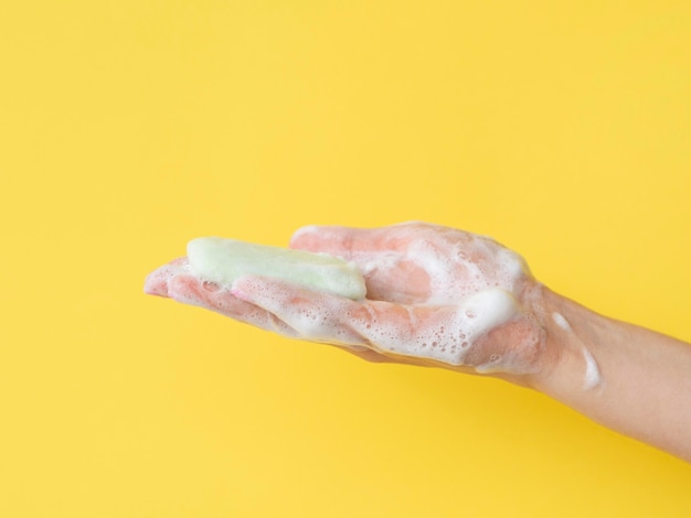 Side view of foamy hand holding soap