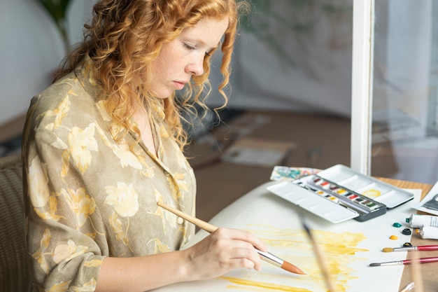 Free photo side view focused woman painting