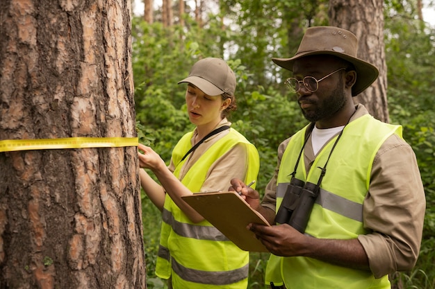 Free photo side view forest wardens wearing vests