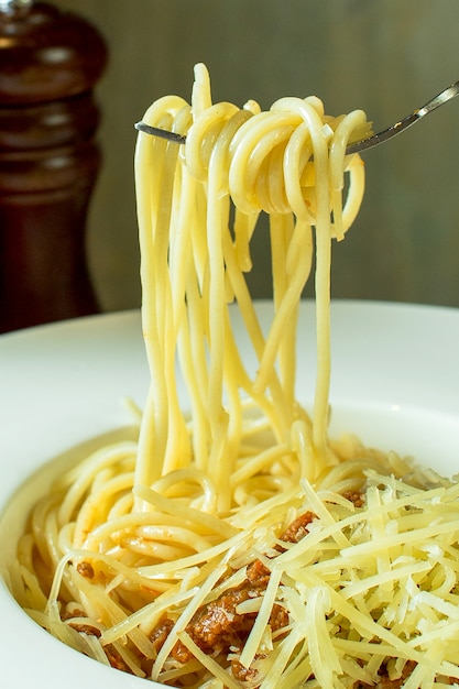 Free photo side view of fork with spaghetti around