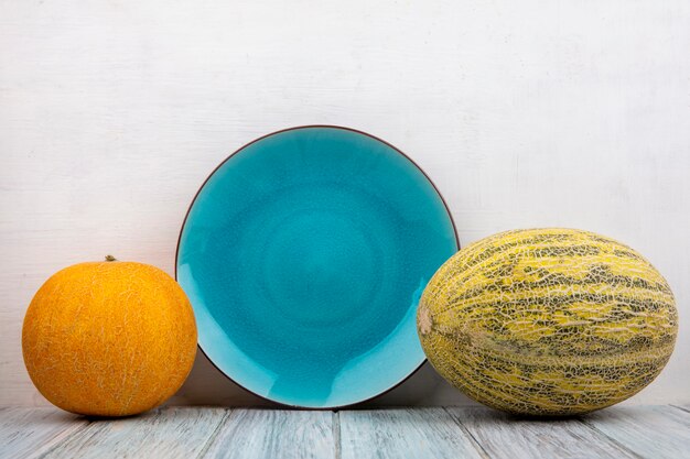 Side view of fresh and delicious melons on white surface with copy space