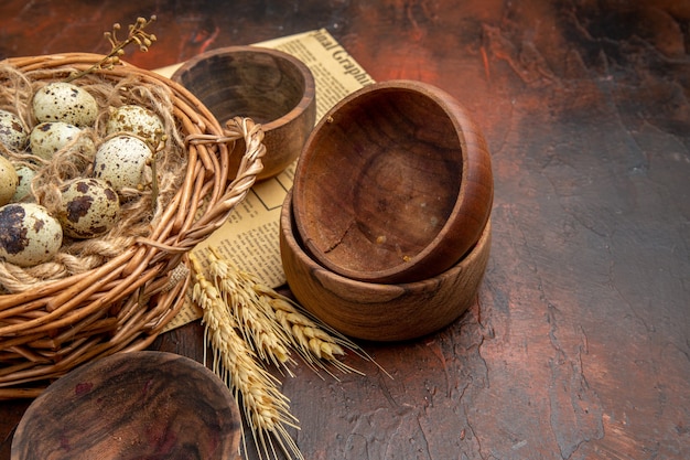 Side view of fresh organic poultry farm eggs in a tissue basket on an old newspaper on a brown background