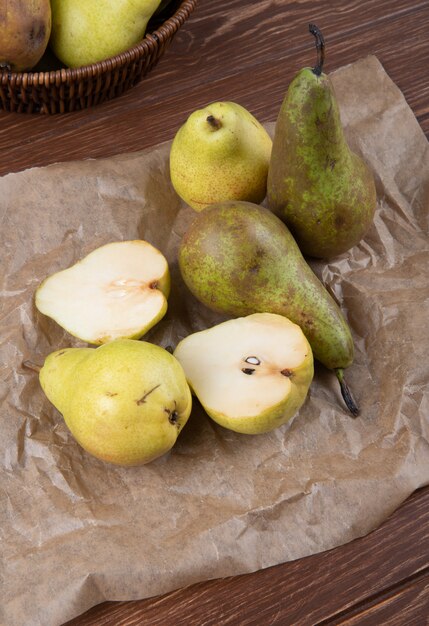 Side view of fresh ripe pears on brown parchment paper on wooden backgroundside view of fresh ripe pears on brown parchment paper on wooden background