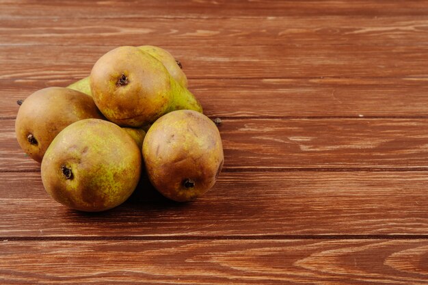 Side view of fresh ripe pears on a wooden background with copy space