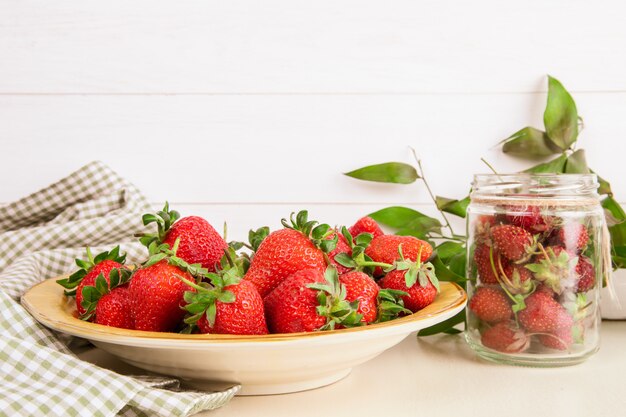 Side view of fresh ripe strawberries on plate on white