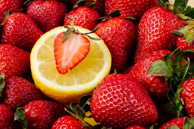 Side view fresh strawberry with slice of lemon on a plate