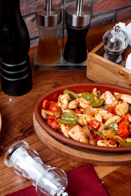 Foto gratuita vista laterale del pollo fritto e delle verdure su una tavola di legno