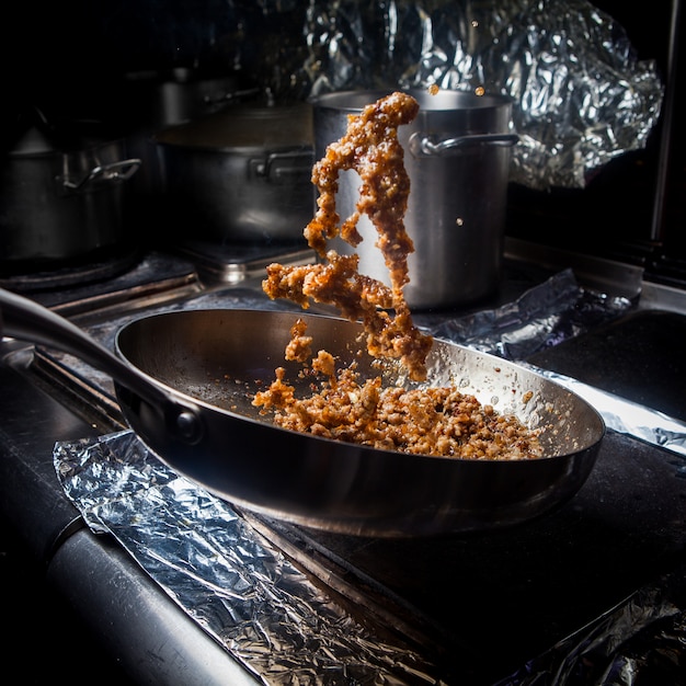 Side view fried minced with pan and foil in stove