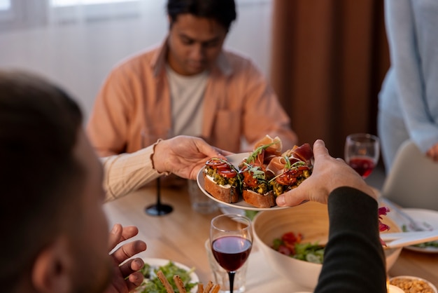 Free photo side view friends at dinner party