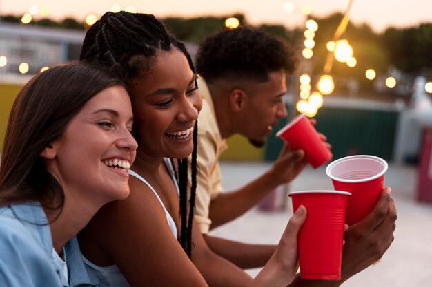 Side view friends eating outdoors