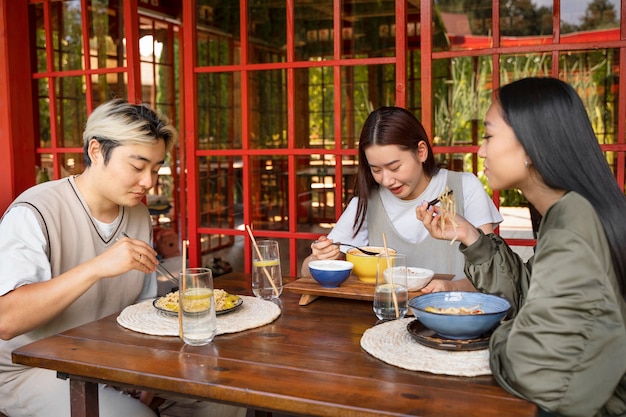 Free photo side view friends eating together