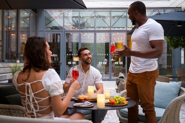 Foto gratuita vista laterale degli amici che si godono una cena