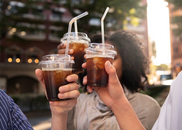 アイスコーヒーを持っている側面図の友人