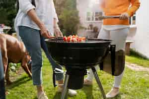 Free photo side view friends making barbecue