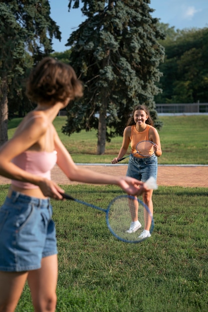 Free photo side view friends playing badminton