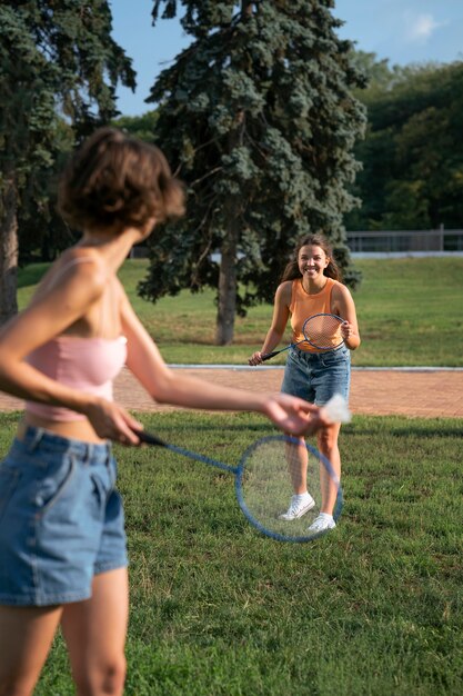 Side view friends playing badminton