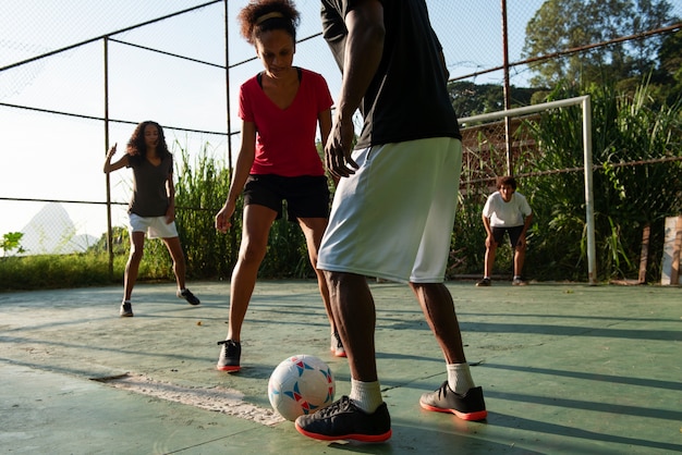 Amici di vista laterale che giocano a calcio