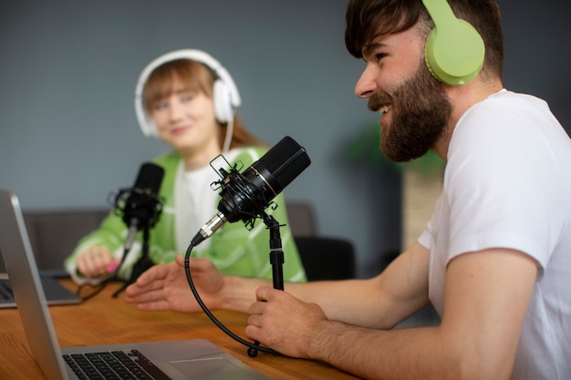 Free photo side view friends recording podcast together