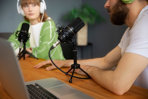 Free photo side view friends recording podcast together