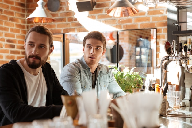 Side view of friends sitting on bar