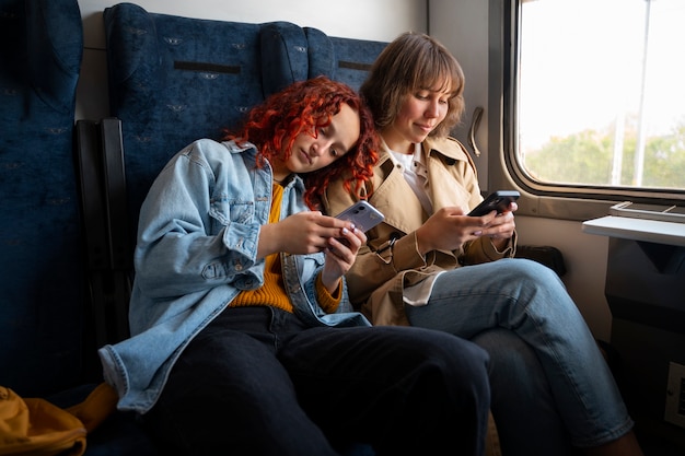 Foto gratuita amici di vista laterale che viaggiano in treno