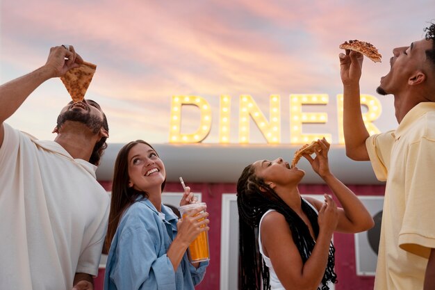 Free photo side view friends with food outdoors