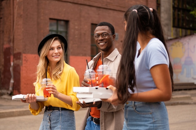 Foto gratuita vista laterale amici con pizza fuori