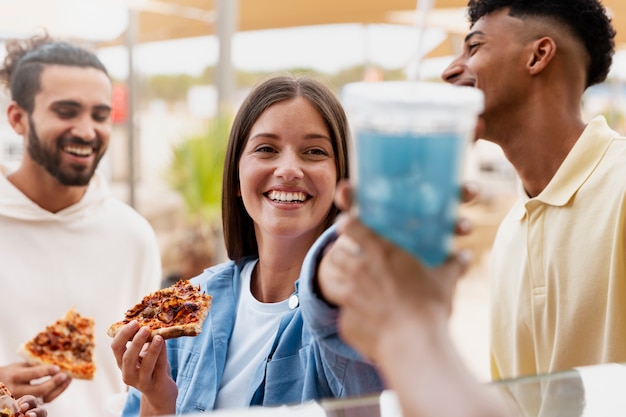 Foto gratuita amici di vista laterale con le fette di pizza