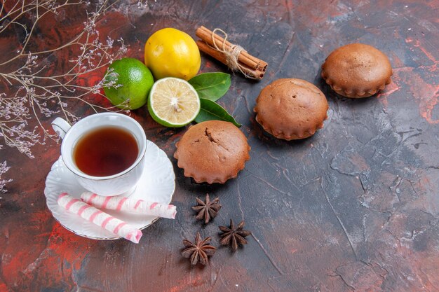 Side view from afar citrus fruits citrus fruits a cup of tea cupcake star anise cinnamon