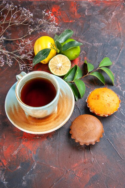 Side view from afar a cup of tea a cup of tea the appetizing citrus fruits with leaves cupcakes