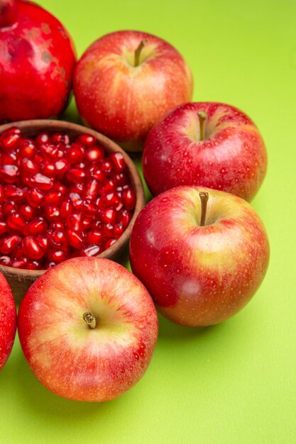 遠くの果物からの側面図テーブル上のザクロの種の食欲をそそるリンゴボウル