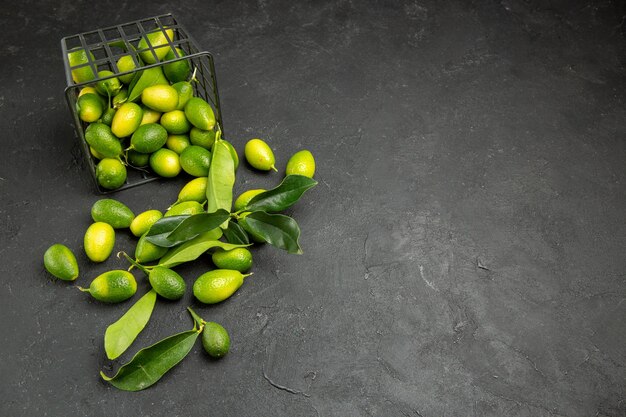 Side view from afar fruits citrus fruits with leaves next to the basket with fruits