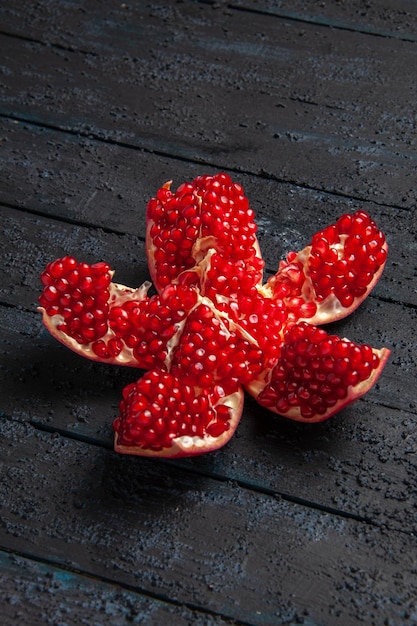 Side view from afar pilled pomegranate appetizing pilled pomegranate in the center of wooden table