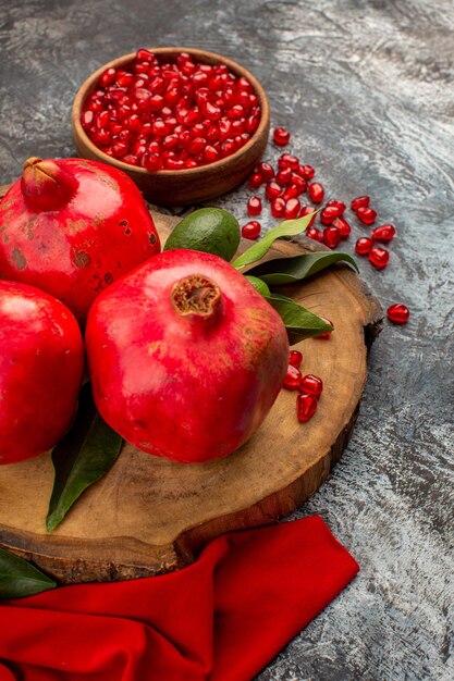 Side view from afar pomegranates the bowl of pomegranate seeds red pomegranates with green leaves