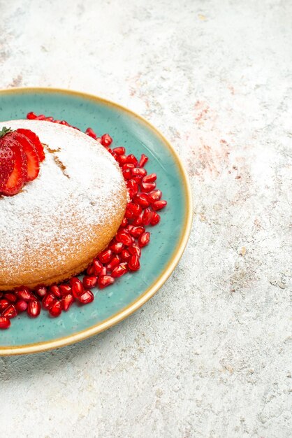 Side view from afar strawberry pomegranate the appetizing cake with strawberries on the grey table