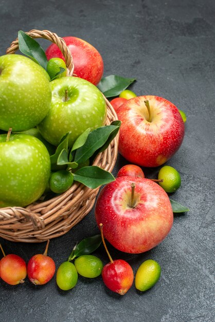 Side view fruits berries and fruits basket of green apples with leaves