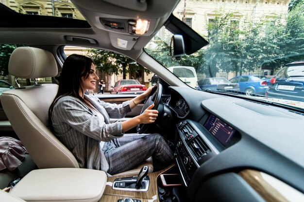 車を運転している欲求不満の若いビジネス女性の側面図。