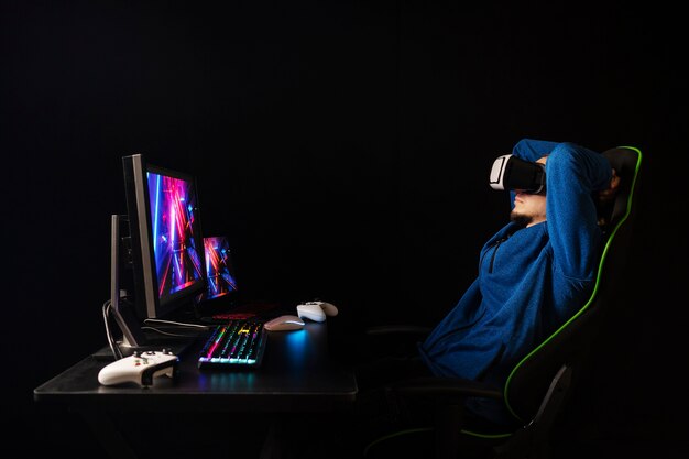 Side view gamer sitting on chair