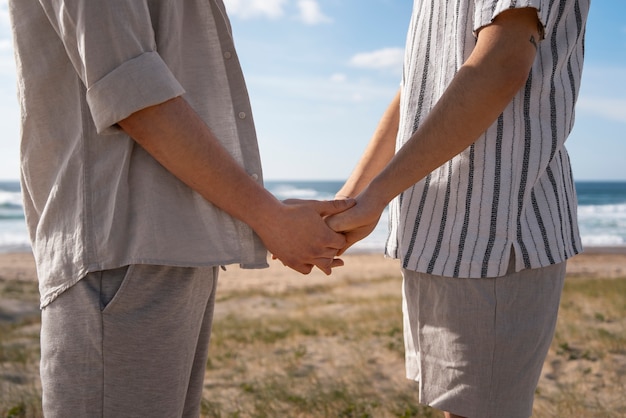 Foto gratuita coppia gay vista laterale in spiaggia