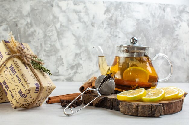 白いテーブルの上の木製トレイにレモンとシナモンライムとギフト紅茶の側面図